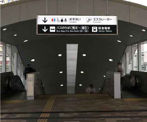 スロープを道なりに進むと「バス乗り場（南４～南６）・阪急電車」への案内板があるのでそこを下に降りてください。